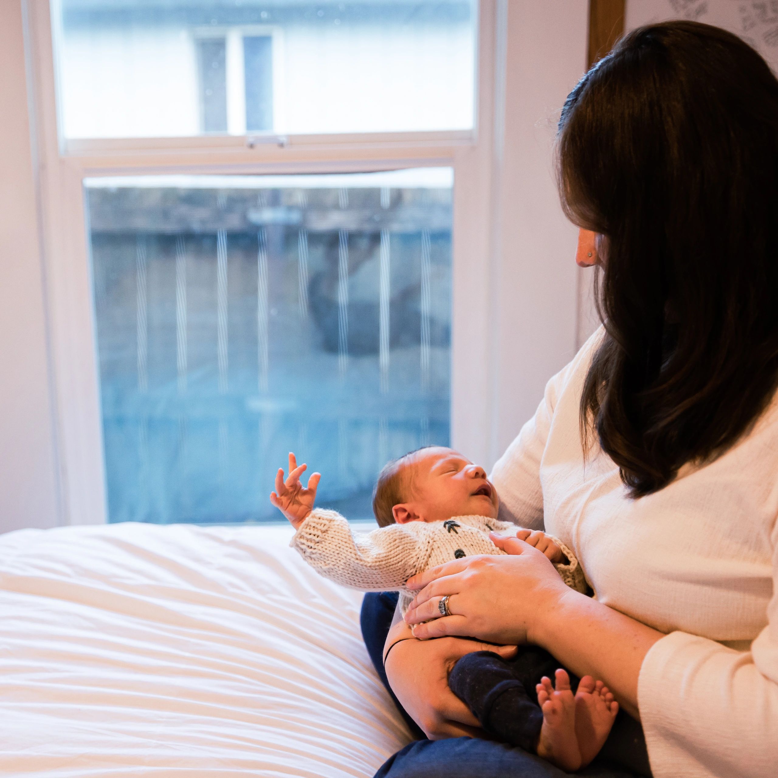 Mother holding her newborn baby at home