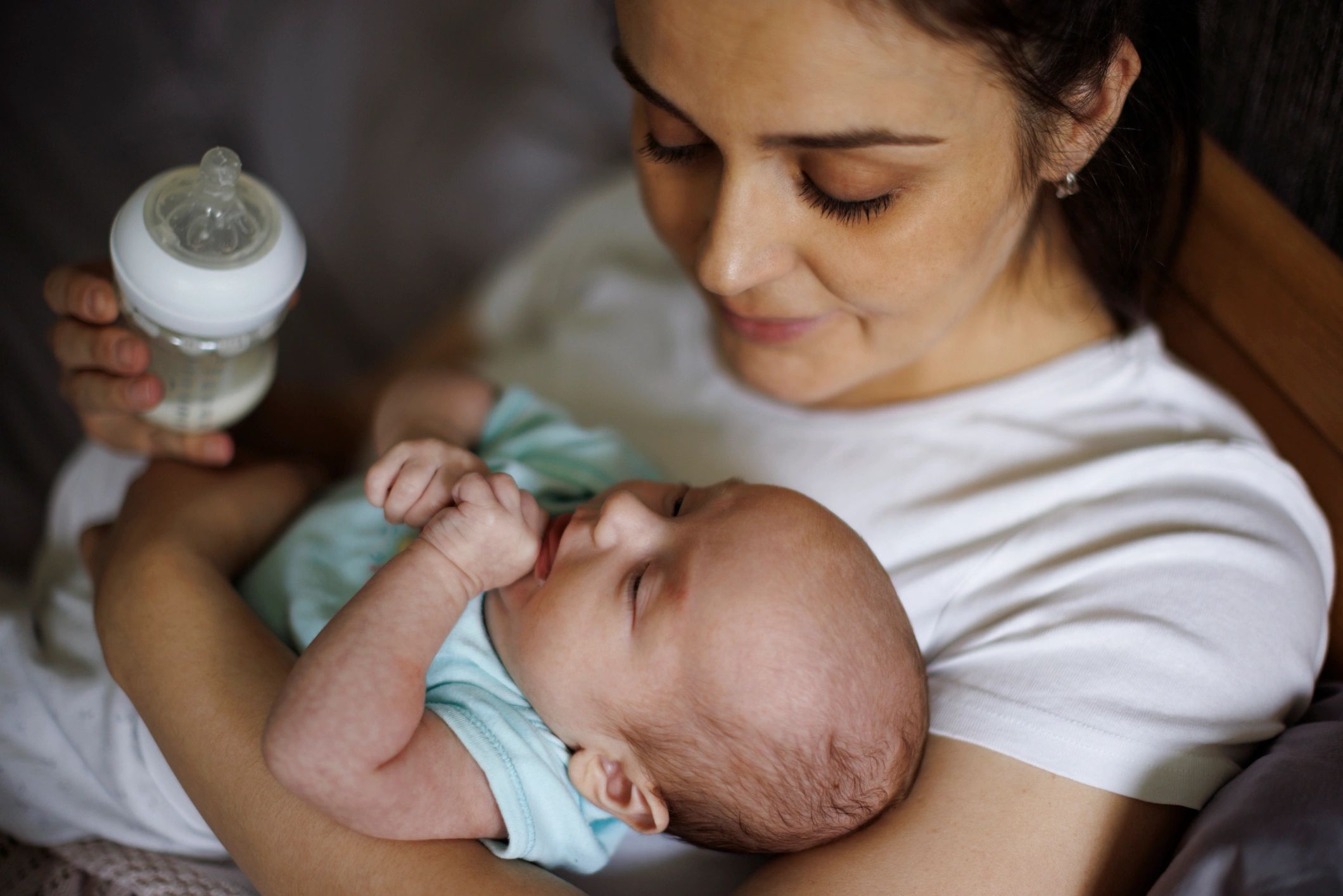 Mother feeding her newborn baby at home