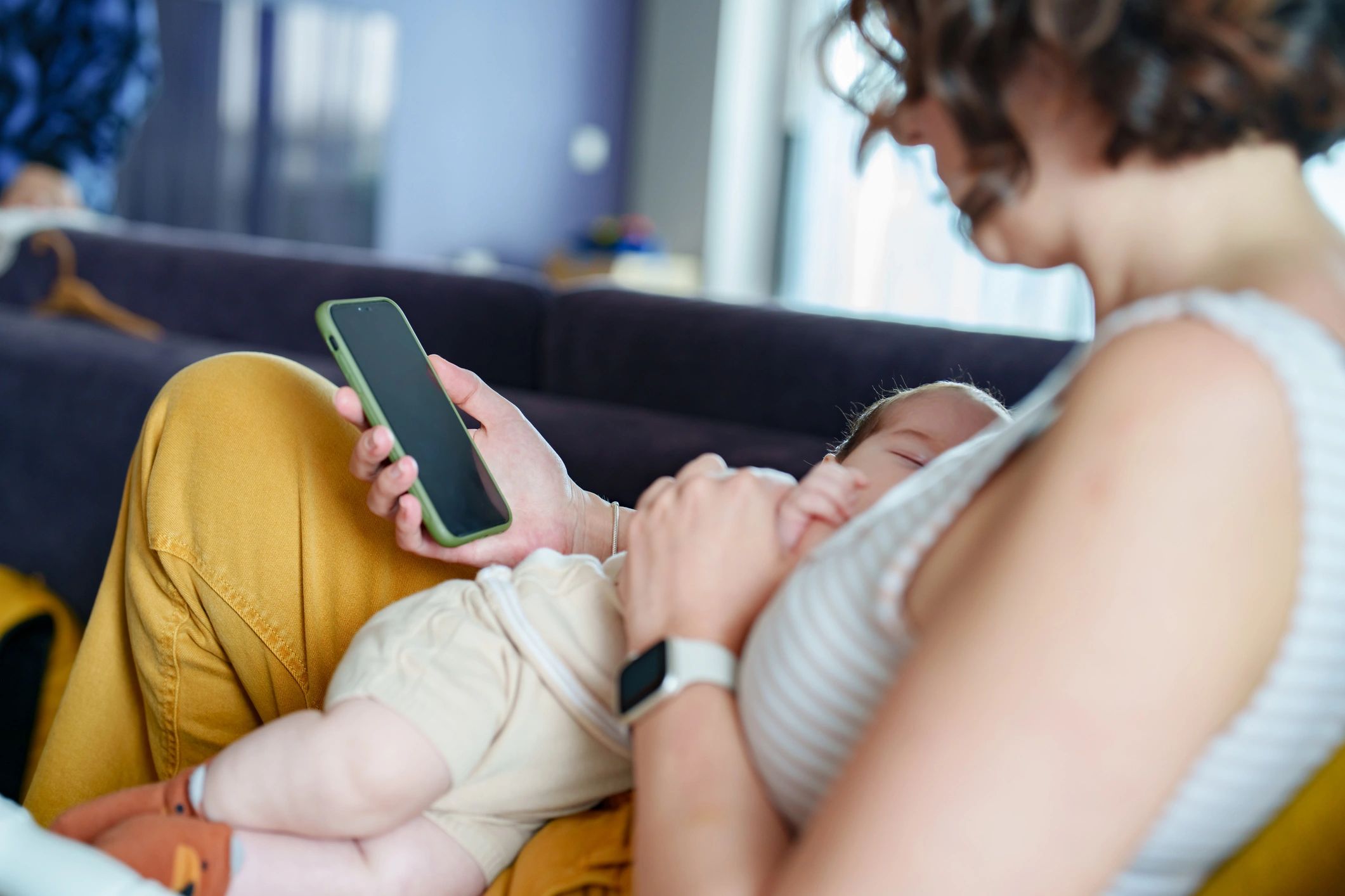 Mother breastfeeding her baby at home