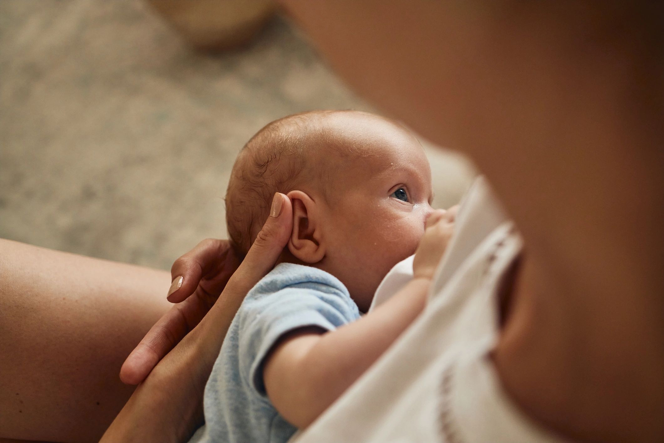 Mother breastfeeding her newborn at home
