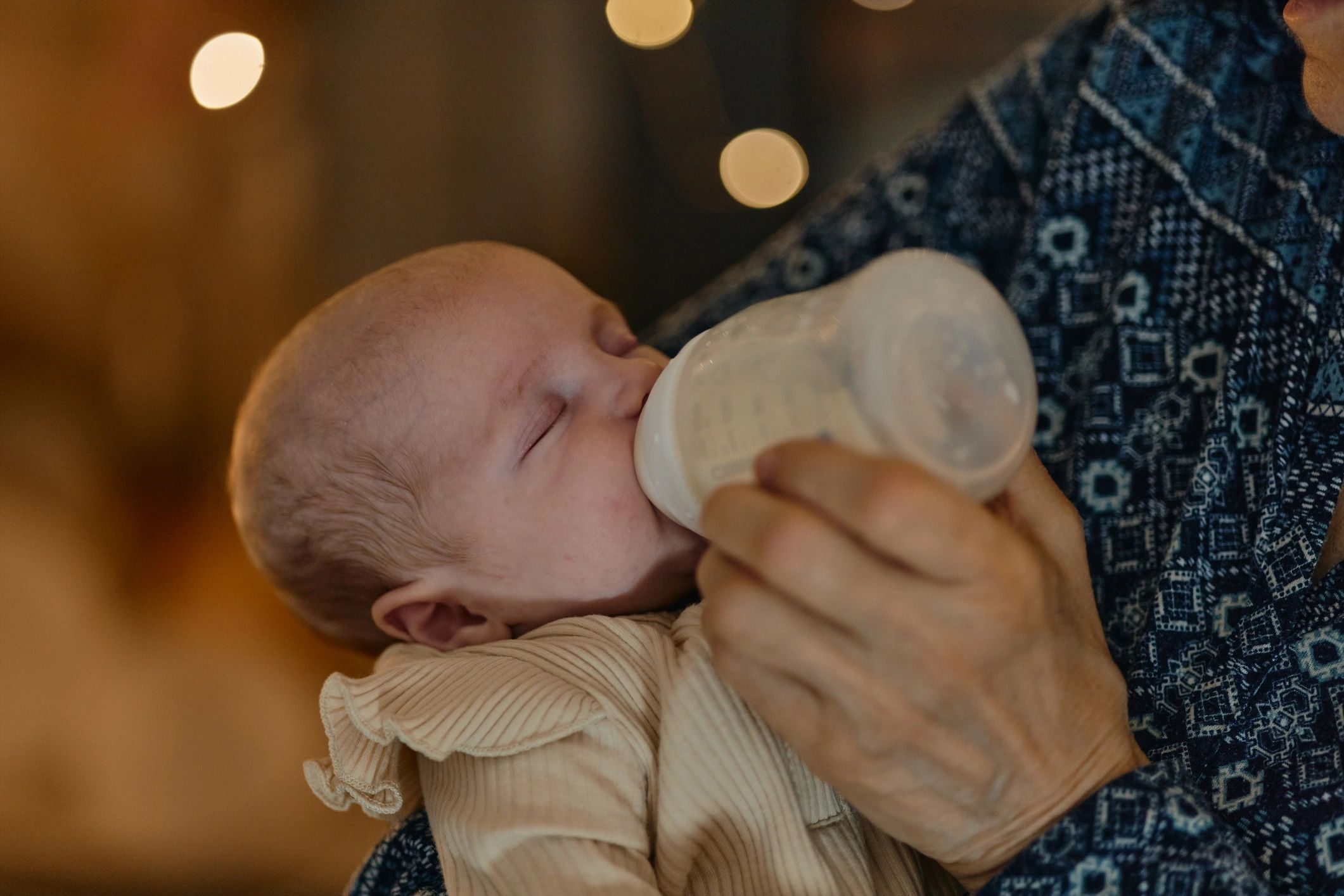 Parent feeding an infant at home